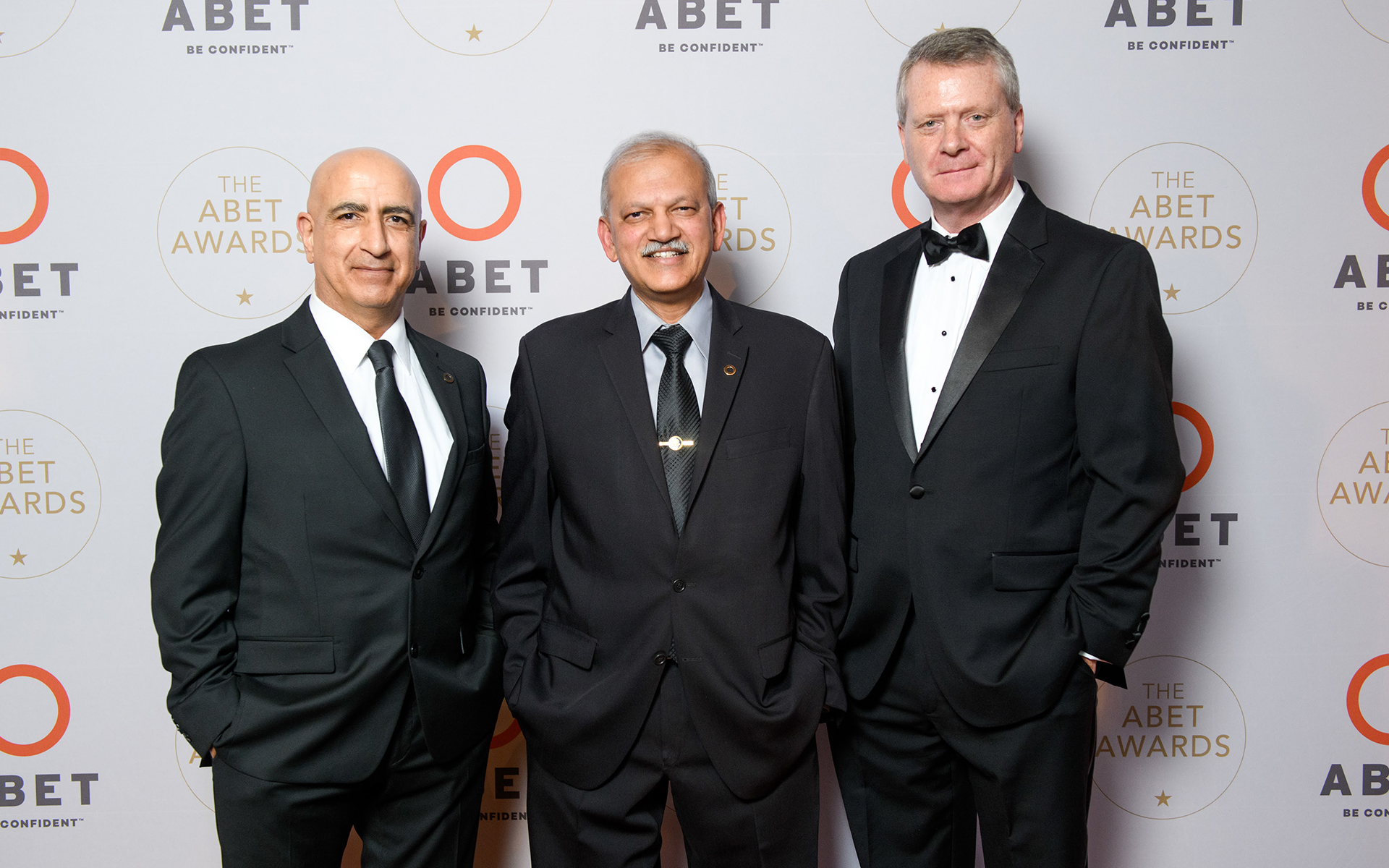 Three men in suits standing together at the ABET Awards